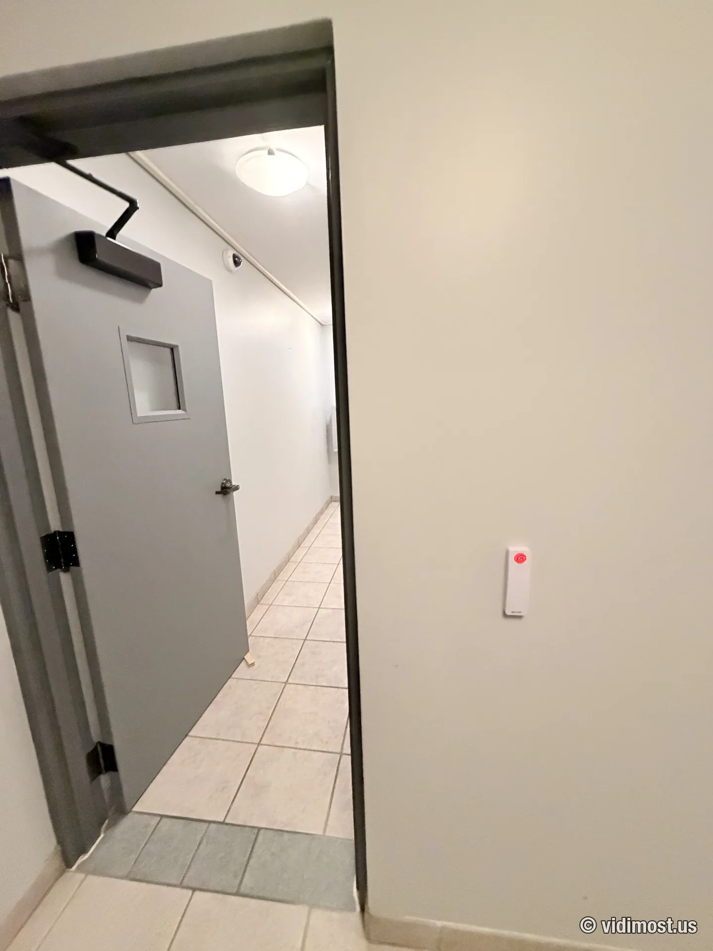 Multi-tenant common-area door with closer and white Brivo reader, dome camera visible in the corridor