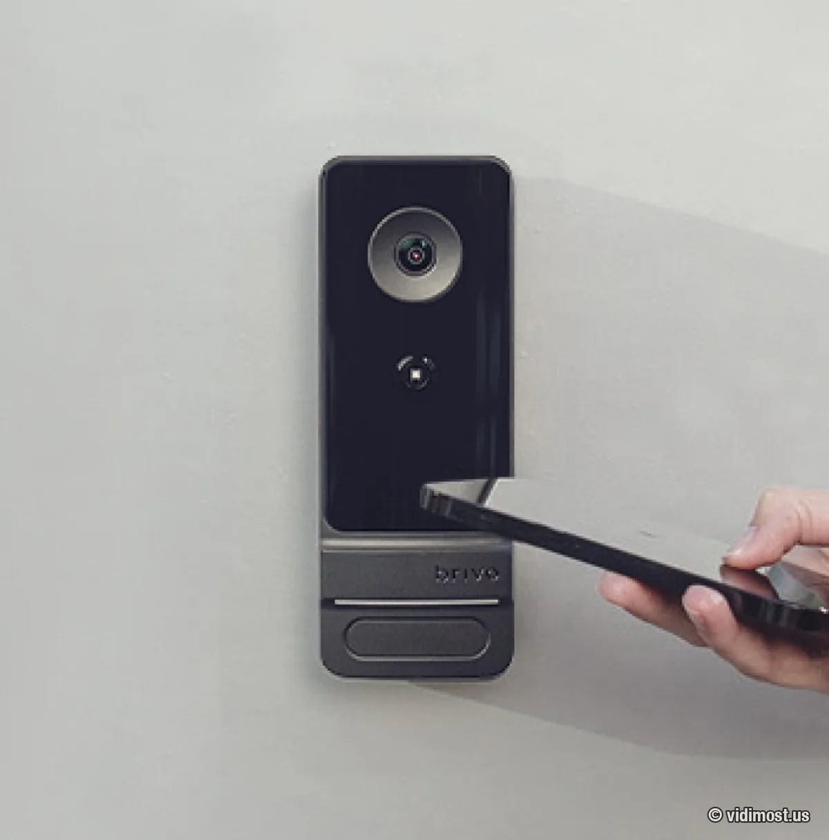 Phone tapped against the Brivo Door Station — the unit doubles as a mobile-credential reader